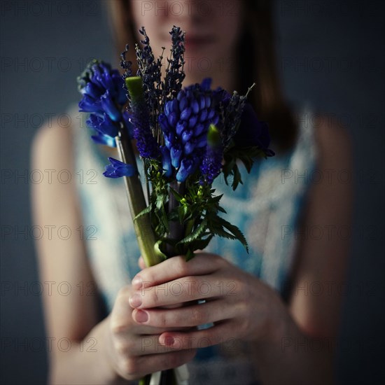 Caucasian teenage girl holding bouquet of flowers