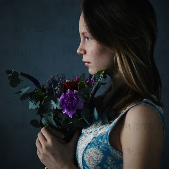 Caucasian teenage girl holding bouquet of flowers