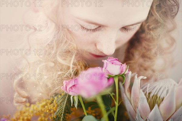 Caucasian teenage girl smelling bouquet of flowers