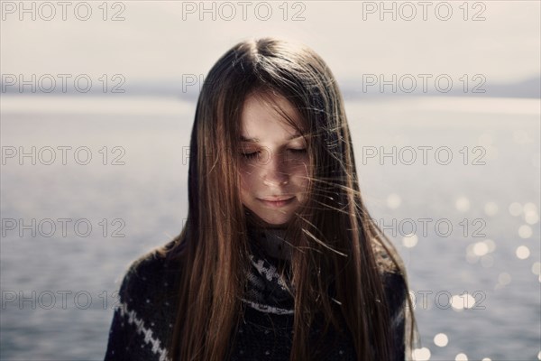 Pensive Caucasian girl at lake