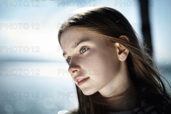 Pensive Caucasian girl at lake