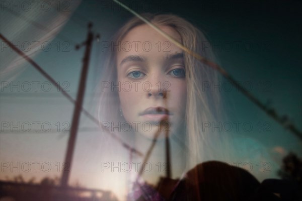 Double exposure of Caucasian girl in blue sky