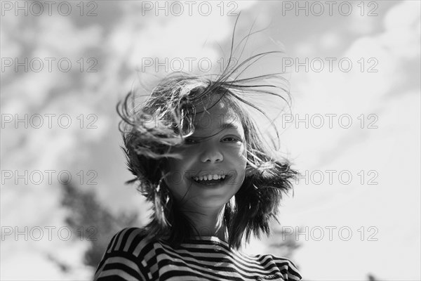 Smiling Caucasian girl with hair blowing in wind