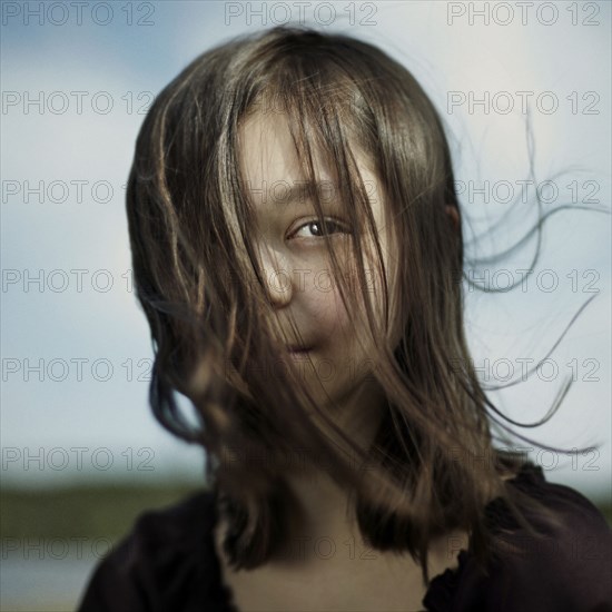 Hair of serious Caucasian girl blowing in wind