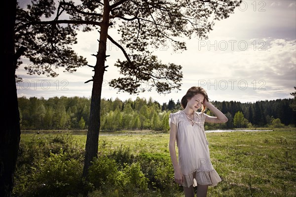 Pensive Caucasian girl standing in field