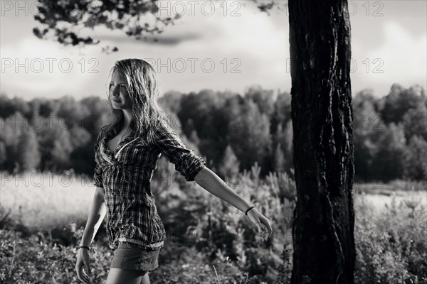 Caucasian girl walking near tree