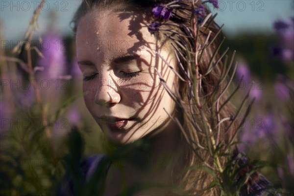 Pensive Caucasian girl sweating near wildflowers