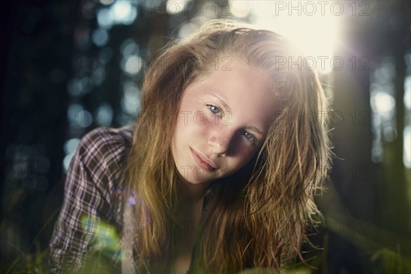 Serious Caucasian girl in sunny forest