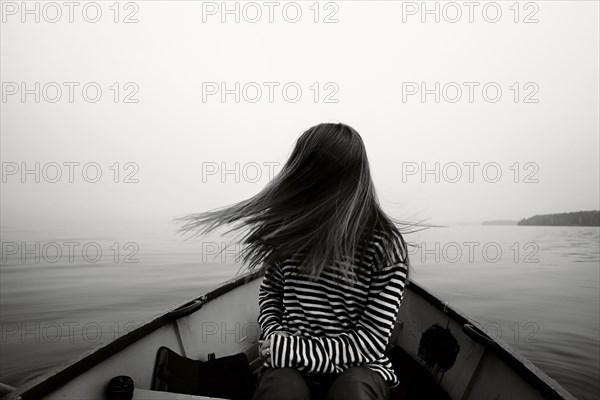 Caucasian girl tossing hair in boat