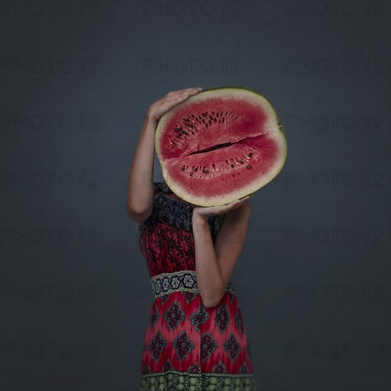 Caucasian girl holding enormous sliced watermelon