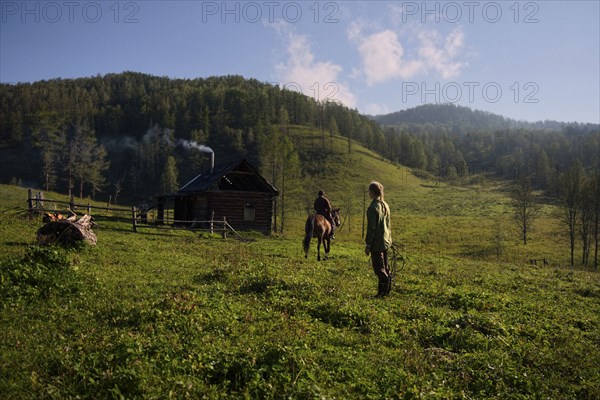 Caucasian girl watching girl riding horse