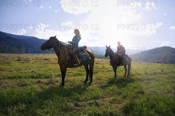 Caucasian girls riding horses in field