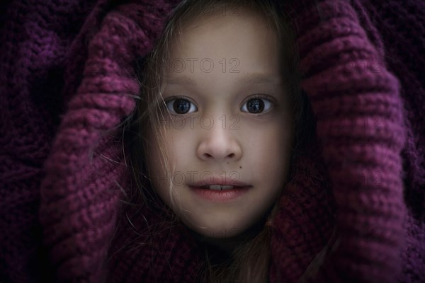 Portrait of Caucasian girl covering head with sweater