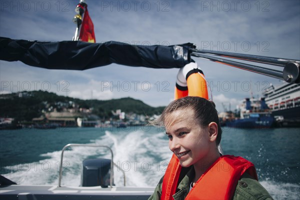 Caucasian woman wearing life-jacket in speedboat