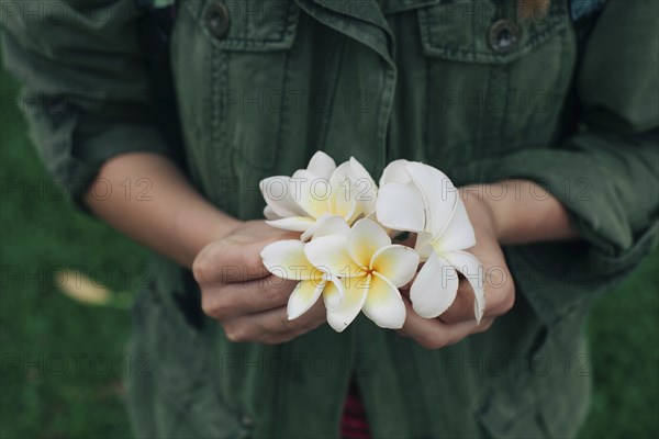 Hands of Caucasian woman holding flowers