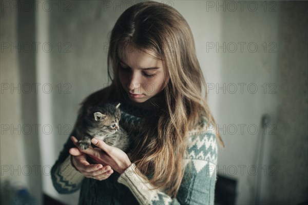 Caucasian woman holding kitten