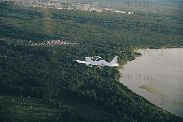 Aerial view of airplane flying over trees