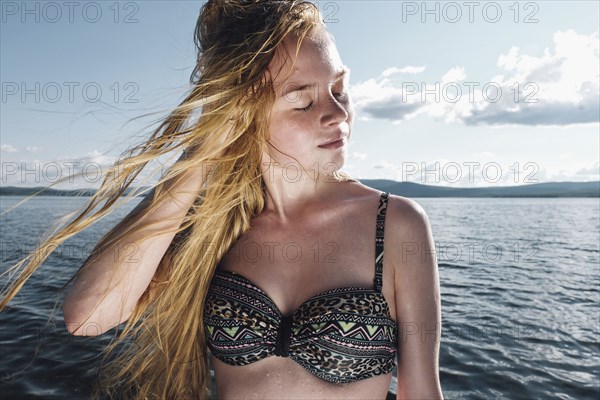 Wind blowing hair of Caucasian teenage girl in ocean