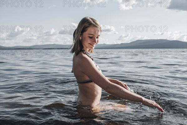 Caucasian woman splashing in ocean