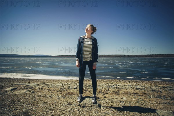Caucasian teenage girl standing on sunny beach