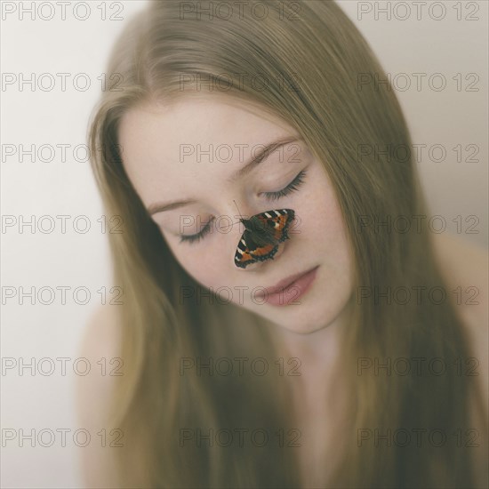 Butterfly on nose of Caucasian teenage girl