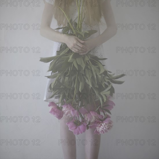 Caucasian teenage girl holding flowers upside-down