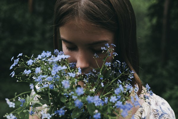 Caucasian woman smelling flowers