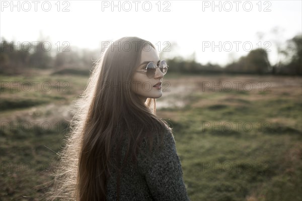 Caucasian woman wearing sunglasses in field