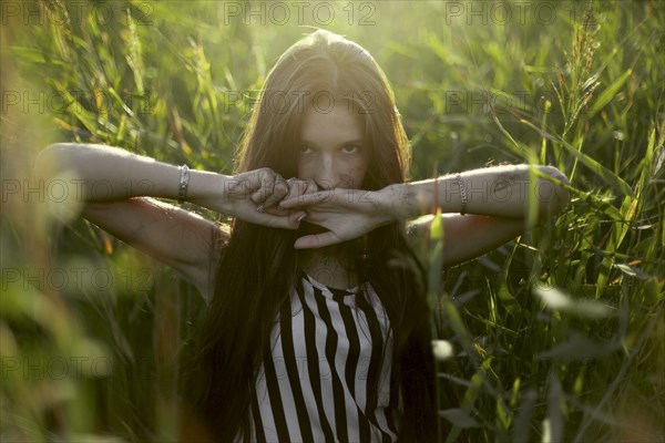 Caucasian woman covering mouth with hands in field