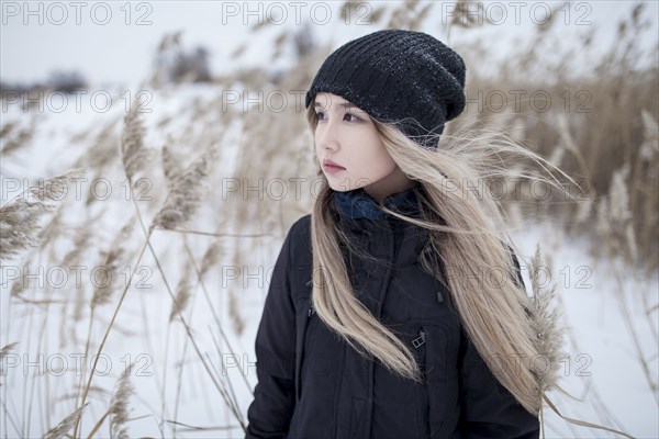Wind blowing hair of Asian teenage girl in winter