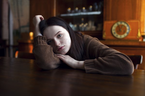 Depressed Caucasian girl leaning on table