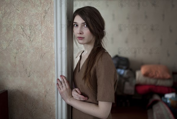 Serious Caucasian woman leaning in doorway