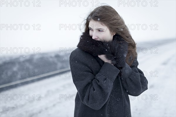 Caucasian woman nestling in fur collar outdoors in winter