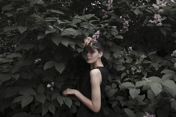 Shy Caucasian woman standing in flowering tree