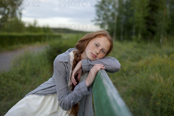 Portrait of pensive Caucasian girl sitting on bench