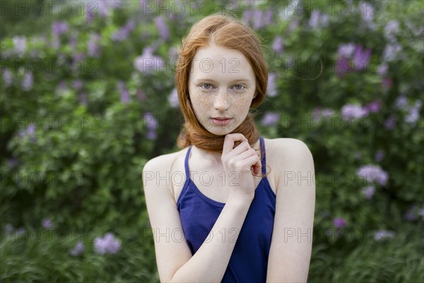 Caucasian teenage girl wrapping hair around neck