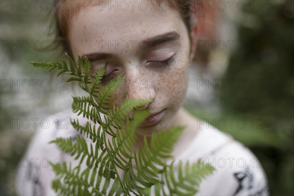 Caucasian girl smelling leaves