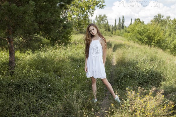 Caucasian girl standing in field of grass