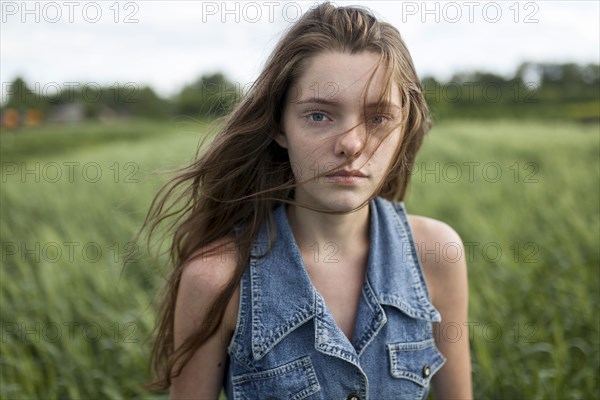 Wind blowing hair of Caucasian woman in field