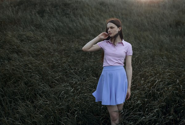 Caucasian girl standing in windy field