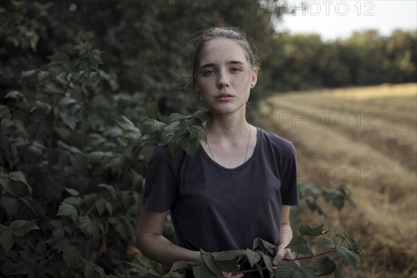 Portrait of Caucasian teenage girl holding branch