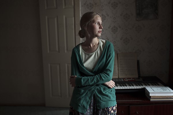 Portrait of pensive Caucasian woman leaning on piano