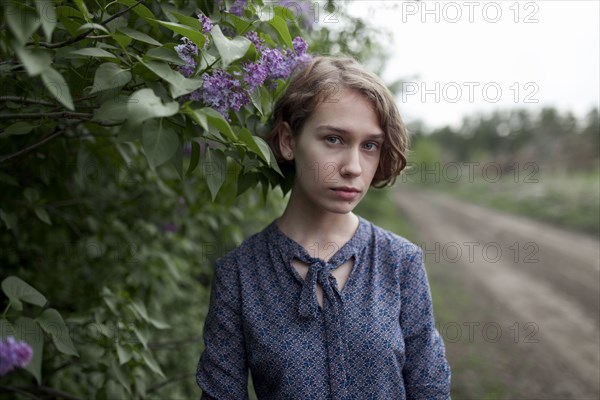 Pensive Caucasian woman standing near flowers