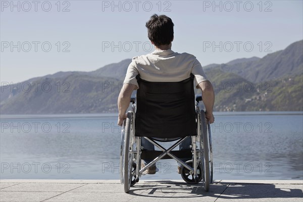 Caucasian man in wheelchair sitting on dock