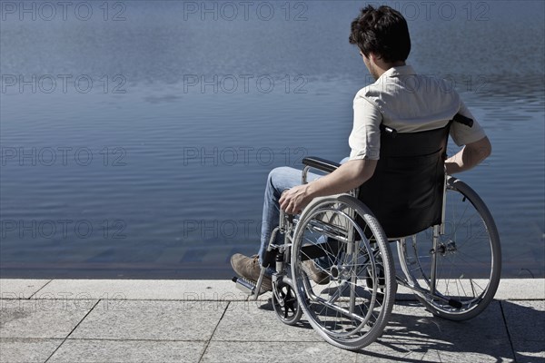 Caucasian man in wheelchair sitting on dock