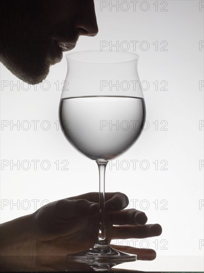 Man drinking water from wine glass