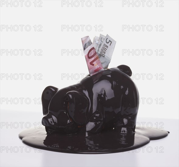 Euro banknotes in melting piggy bank