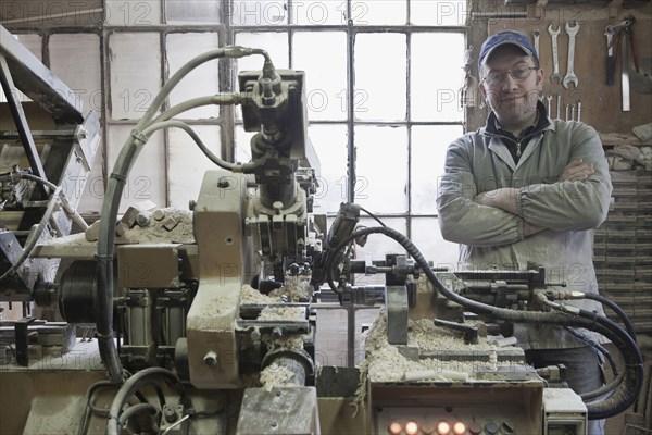 Carpenter standing near woodshop machinery