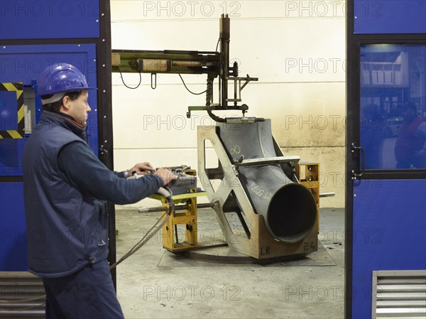 Caucasian worker working on steel pipe in factory