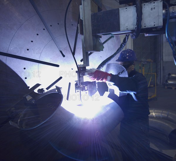 Caucasian worker working on steel pipe in factory